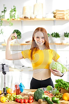 beautiful female stand holding cabbage and broccoli in hands, lead heathy lifestyle and eating