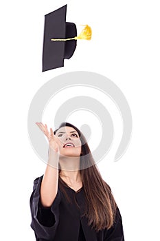 Beautiful female student throws up his graduation cap in celebration.