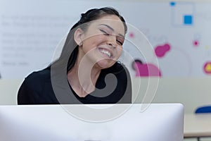 Beautiful female  IT student working at her computer lab.  Female studentsmoling and looking into camera. Education and technology