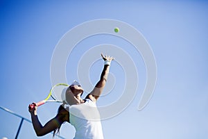 Beautiful female tennis player serving