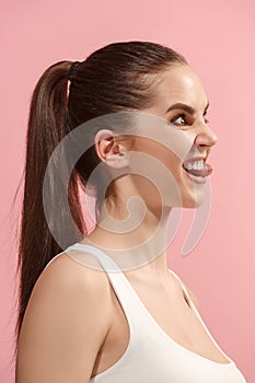 The young woman is looking crazy on the pink background.