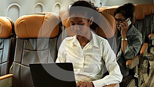 Beautiful female tourist using laptop while sitting on plane.