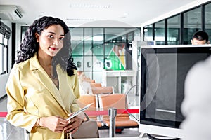 Beautiful female traveler holds passport and boarding pass at check in area airport terminal, waits for checking information at