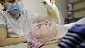 Beautiful females face with closed eyes being cleaned with steam therapy in beauty spa