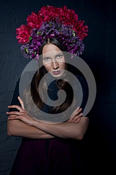 Beautiful femme fatale in a headdress from fresh colorful flower