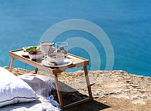 Beautiful festive breakfast with seascape view on the brink of a precipice. Travel and healthy lifestyle concept