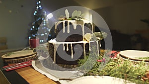 Beautiful festive cozy Christmas tree atmosphere in dining room with ginger cake on New Year celebration dinner table