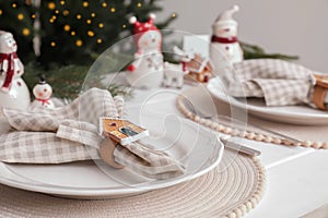 Beautiful festive place setting with stylish decor for Christmas dinner on white wooden table, closeup. Space for text