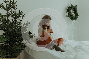 Beautiful festive portrait of a teen girl. Christmas light home background. Waiting for a miracle make a wish under the Christmas