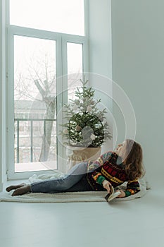 Beautiful festive portrait of a teen girl. Christmas light home background. Waiting for a miracle make a wish under the Christmas