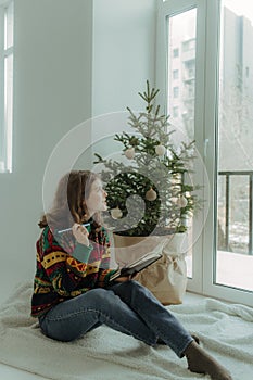 Beautiful festive portrait of a teen girl. Christmas light home background. Waiting for a miracle make a wish under the Christmas