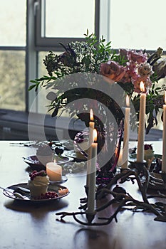 The beautiful festive table with rustic bouquet, dessert and candles