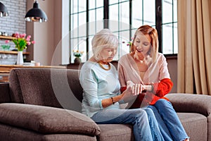 Beautiful fiancee happily showing elderly granny engagement ring