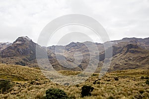 Beautiful field with amazing rocky mountains and hills in the background and amazing cloudy sky