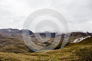 Beautiful field with amazing rocky mountains and hills in the background and amazing cloudy sky