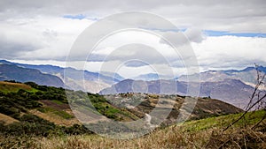 Beautiful field with amazing rocky mountains and hills in the background and amazing cloudy sky