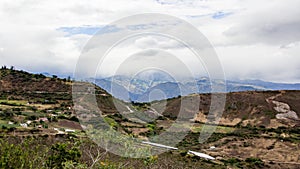 Beautiful field with amazing rocky mountains and hills in the background and amazing cloudy sky