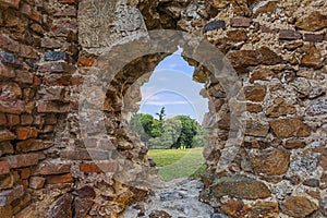 Beautiful field view and the ancient window of an old ruined castle