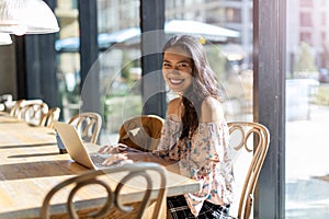 Beautiful Filipino woman using laptop at cafe photo