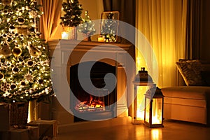 Beautiful fireplace, Christmas tree and other decorations in living room at night. Interior design