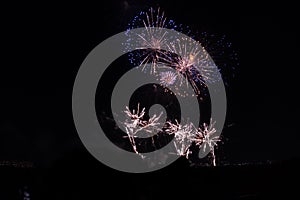 Multiple Fireworks in night sky in a composition in shades gold and blue