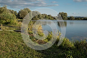 Beautiful fish pond near Badin, Banska Bystrica, Slovakia. Sky and trees mirror reflection in the water. Fishing place. Shining