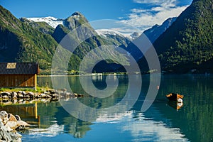 Beautiful fishing house on fjord. Beautiful nature with blue sky, reflection in water and fishing house. Norway