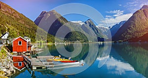 Beautiful fishing house on fjord. Beautiful nature with blue sky, reflection in water and fishing house. Norway