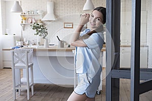 Beautiful fit brunette woman at home in pajama. She eating breakfast on her kitchen. Natural light. Lifestyle healthcare concept