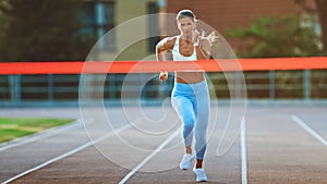 Beautiful Fit Female Runner Crossing the Finish Line on a Professional Sports Arena. Athletic Woma