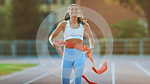 Beautiful Fit Female Runner Crossing the Finish Line on a Professional Sports Arena. Athletic Woma