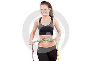 Beautiful fit girl measuring her waist with three measuring tapes.