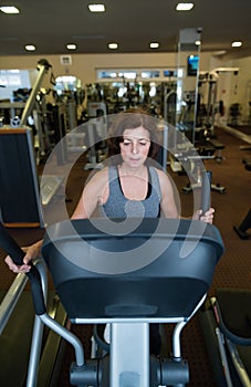 Beautiful fit senior woman in gym doing cardio work out.