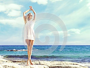 Beautiful, fit and girl in white bikini posing on a beach a