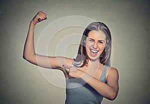 Beautiful fit young healthy model woman flexing muscles showing her strength