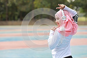 Beautiful fitness athlete asian muslim woman drinking water after work out exercising. Young cute girl standing in sportswear with