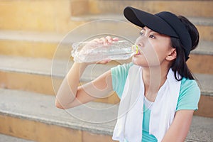 Beautiful fitness athlete woman drinking water