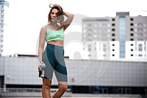 Beautiful fitness girl in sportswear resting after workout session. Concept of sport, wellness and health.
