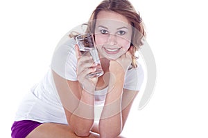 Beautiful fitness model drinking a glass water