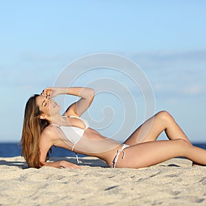 Beautiful fitness woman body sunbathing on the beach