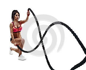 Beautiful fitness woman doing crossfit training using rope photo