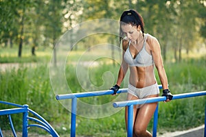 Bellissimo adeguatezza una donna Fare esercizio sul parallelo barre soleggiato esterno 