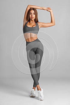 Beautiful fitness woman on gray background