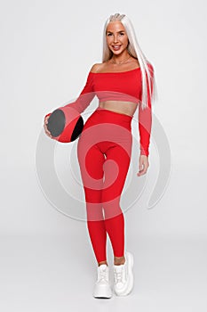 Beautiful fitness woman with med ball. Athletic girl on the gray background