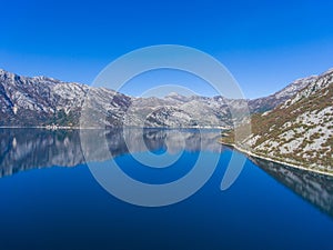 Beautiful fjord of Montenegro. Calm in the Bay of Kotor. Reflection of mountains on water