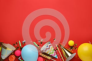 Beautiful flat lay composition with festive items on red background, space for text. Surprise party concept