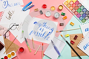 Beautiful flatlay arrangement with watercolors, brushes, glasses, brushpen, paints with handlettered sign anything is possible and