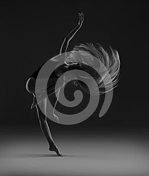 Flexible girl with long blonde hair dancing. Flying hair.