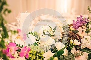 BEAUTIFUL FLORAL DECORATION AT WEDDING TABLE WITH IMPRESSIVE COLOURFUL VENUE AND BLURRED BACKGROUND