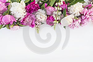 Beautiful floral frame of bunch of purple, pink, and white peonies on white background.